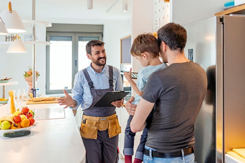 Image of technician talking with customer. AC Maintenance Checklist.